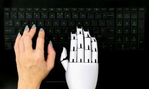 These hands, mechanical and flesh, write together